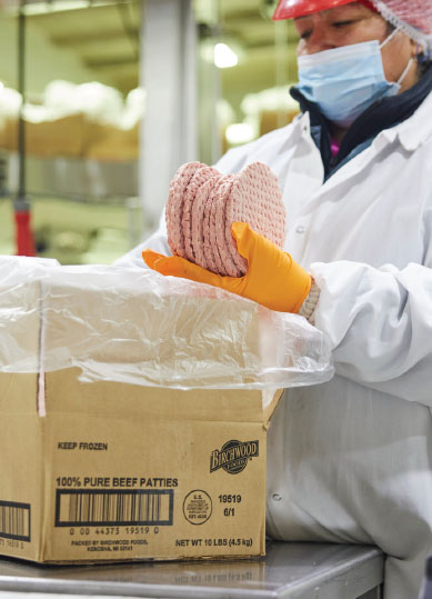 Meat processor work packing frozen hamburgers